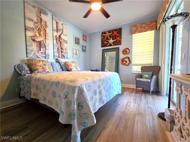 bedroom with wood finished floors, a ceiling fan, and baseboards