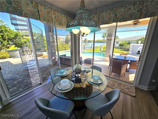 dining space featuring a wealth of natural light, baseboards, wood finished floors, and an inviting chandelier