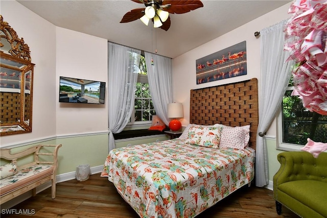 bedroom featuring ceiling fan, baseboards, and wood finished floors