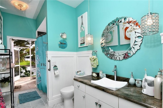 bathroom with marble finish floor, a shower with shower curtain, vanity, and toilet