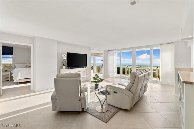 living room featuring light tile patterned flooring, baseboards, and expansive windows