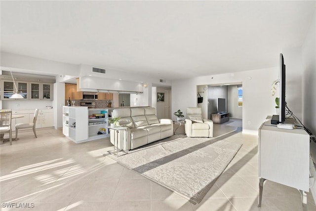 living room featuring visible vents and light tile patterned flooring