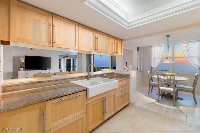 kitchen featuring a sink, a tray ceiling, ornamental molding, and light brown cabinetry