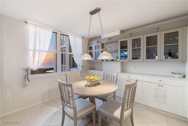 dining area featuring light tile patterned flooring and baseboards