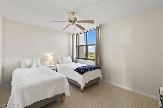 bedroom featuring baseboards, light colored carpet, and ceiling fan