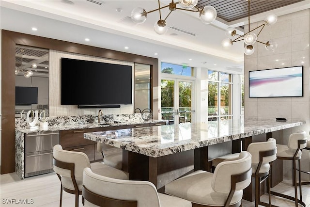 bar with a sink, french doors, and a chandelier