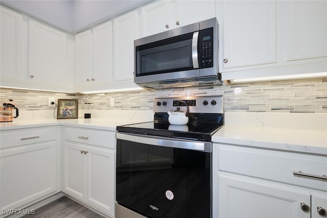 kitchen featuring appliances with stainless steel finishes, backsplash, and white cabinetry