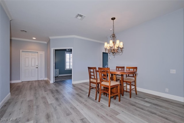 dining area featuring baseboards, crown molding, visible vents, and wood finished floors