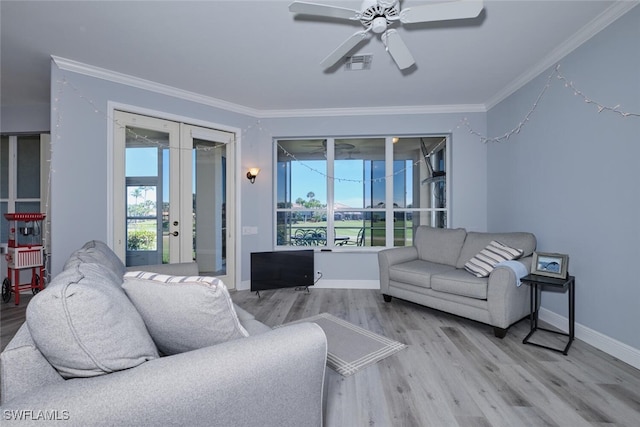 living room featuring wood finished floors, visible vents, baseboards, french doors, and ornamental molding