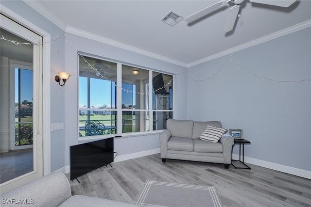 sitting room featuring ornamental molding, visible vents, baseboards, and wood finished floors