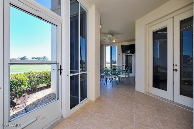 interior space with light tile patterned floors, ceiling fan, and french doors