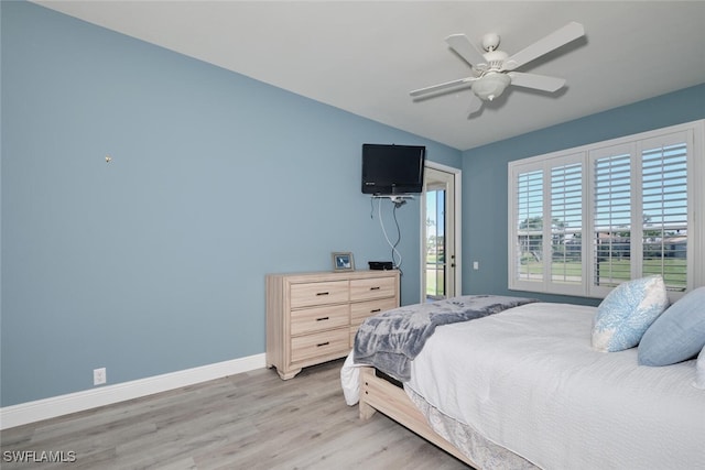 bedroom featuring light wood finished floors, baseboards, lofted ceiling, ceiling fan, and access to outside