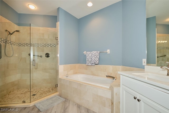 full bathroom featuring a garden tub, a shower stall, and vanity