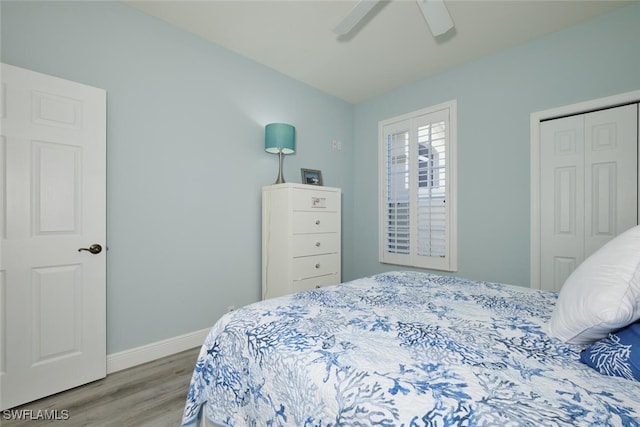 bedroom with a ceiling fan, a closet, baseboards, and wood finished floors