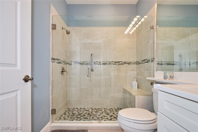 bathroom with a stall shower, vanity, and toilet