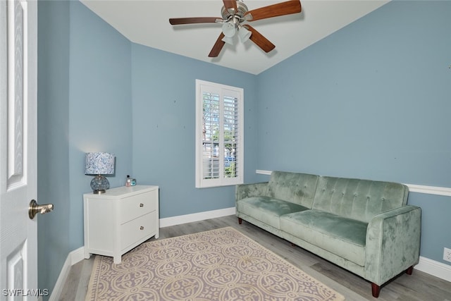 living area featuring ceiling fan, baseboards, and wood finished floors