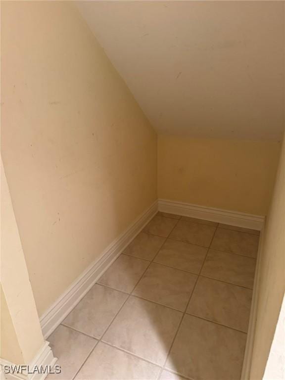 bonus room with vaulted ceiling, baseboards, and light tile patterned floors