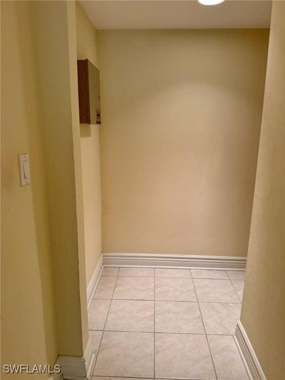 spare room with light tile patterned floors and baseboards