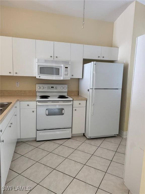 kitchen featuring white appliances, light tile patterned floors, white cabinets, and light countertops