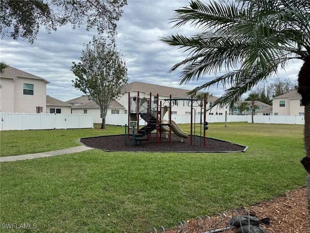 community jungle gym featuring fence and a yard