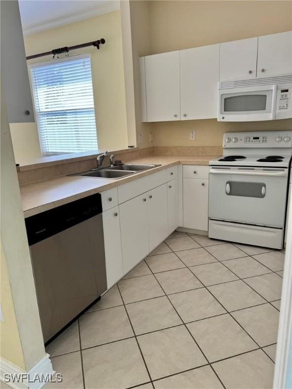 kitchen with white appliances, light tile patterned floors, white cabinets, light countertops, and a sink