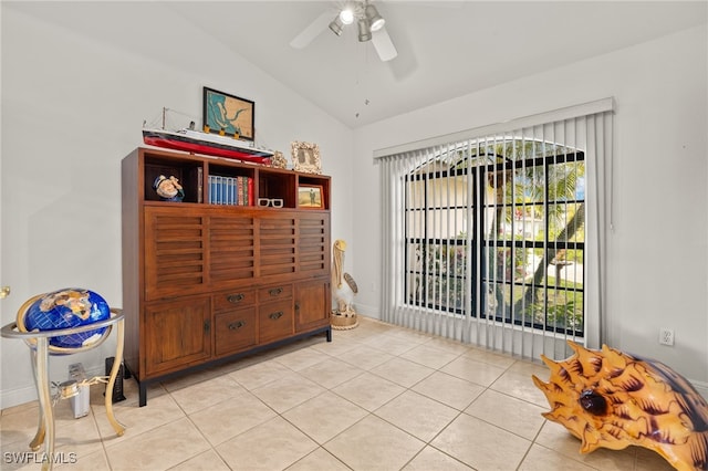 bedroom with vaulted ceiling, light tile patterned flooring, a ceiling fan, and baseboards