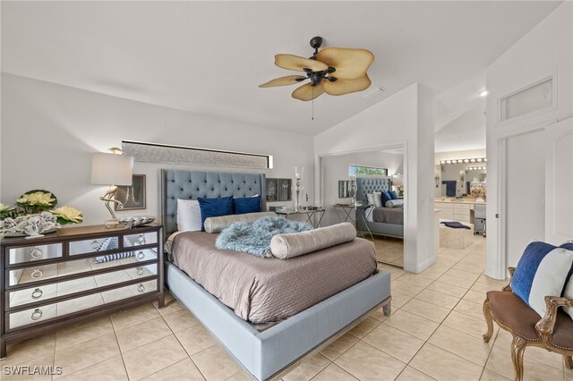 bedroom with light tile patterned floors, ensuite bath, lofted ceiling, and a ceiling fan