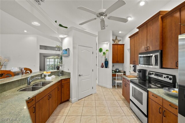 kitchen with light tile patterned floors, light stone countertops, stainless steel appliances, a sink, and recessed lighting