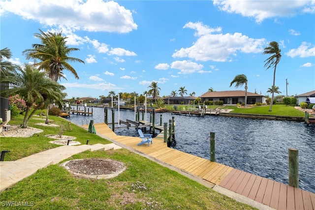 dock area featuring a residential view, a water view, a yard, and boat lift