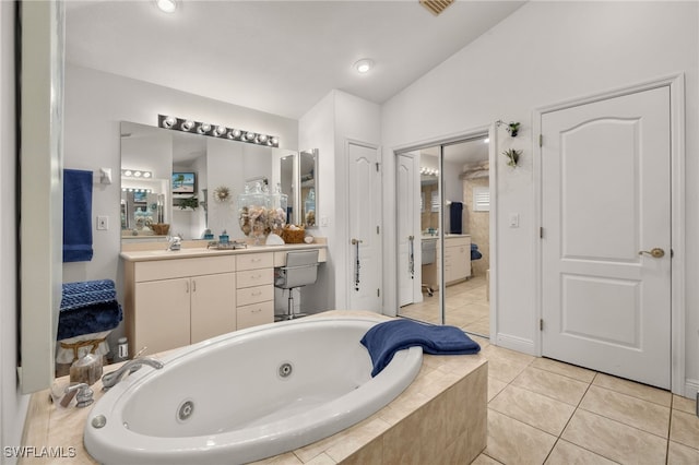 full bath featuring lofted ceiling, a whirlpool tub, tile patterned flooring, and vanity