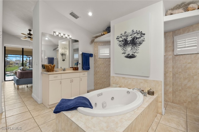 full bathroom with visible vents, lofted ceiling, a whirlpool tub, tile patterned flooring, and vanity