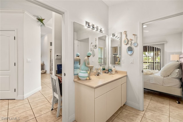 ensuite bathroom with tile patterned flooring, baseboards, connected bathroom, and vanity