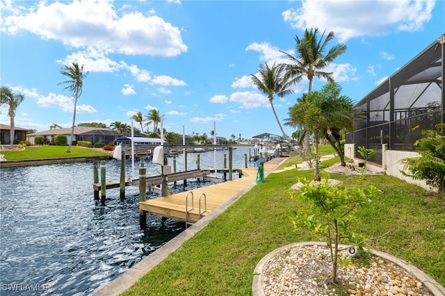 view of dock with a lanai, a water view, a yard, and boat lift