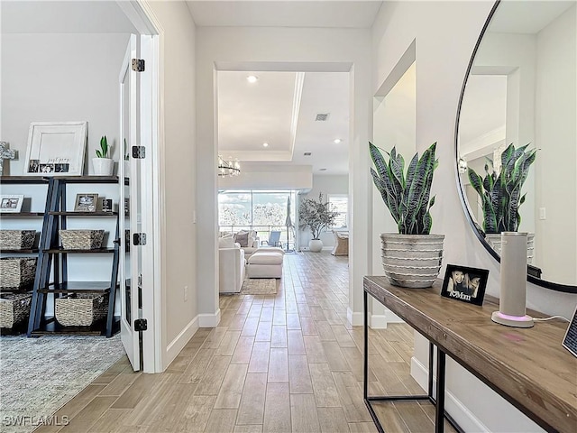 7041 Del Webb Oak Creek Blvd, North Fort Myers, FL 33917 - hallway with recessed lighting, wood finish floors, visible vents, baseboards, and a raised ceiling
