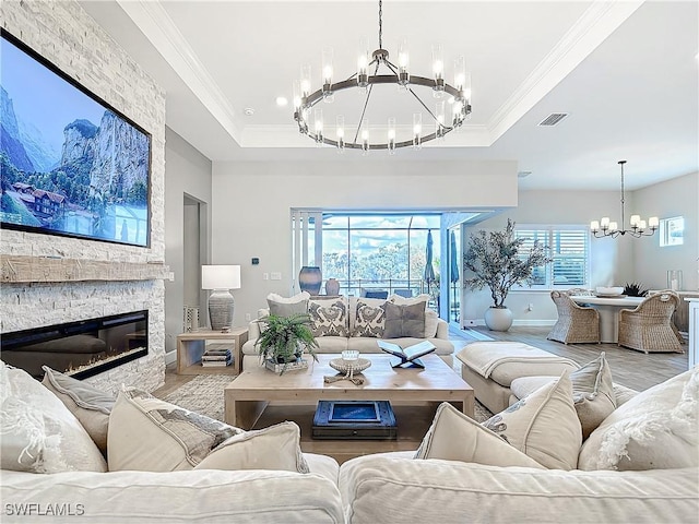 7041 Del Webb Oak Creek Blvd, North Fort Myers, FL 33917 - living area with visible vents, a raised ceiling, wood finished floors, an inviting chandelier, and a stone fireplace