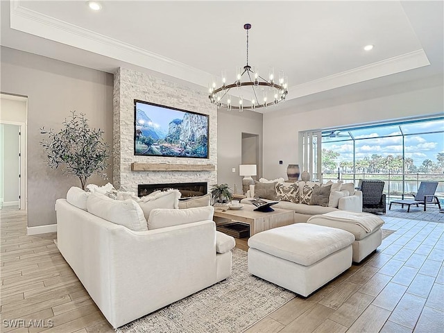 7041 Del Webb Oak Creek Blvd, North Fort Myers, FL 33917 - living room with crown molding, a raised ceiling, wood tiled floor, a stone fireplace, and baseboards