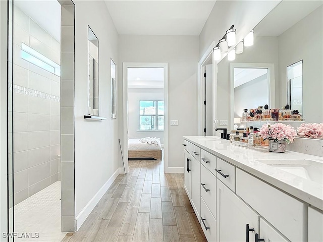 7041 Del Webb Oak Creek Blvd, North Fort Myers, FL 33917 - ensuite bathroom with double vanity, connected bathroom, a sink, wood finished floors, and walk in shower