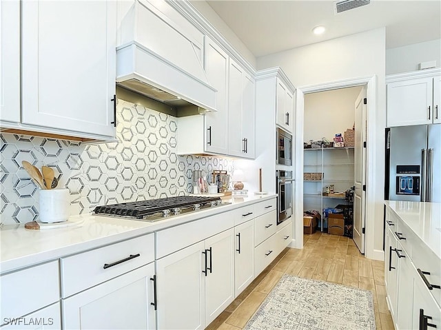 7041 Del Webb Oak Creek Blvd, North Fort Myers, FL 33917 - kitchen featuring stainless steel appliances, light countertops, white cabinets, and custom range hood
