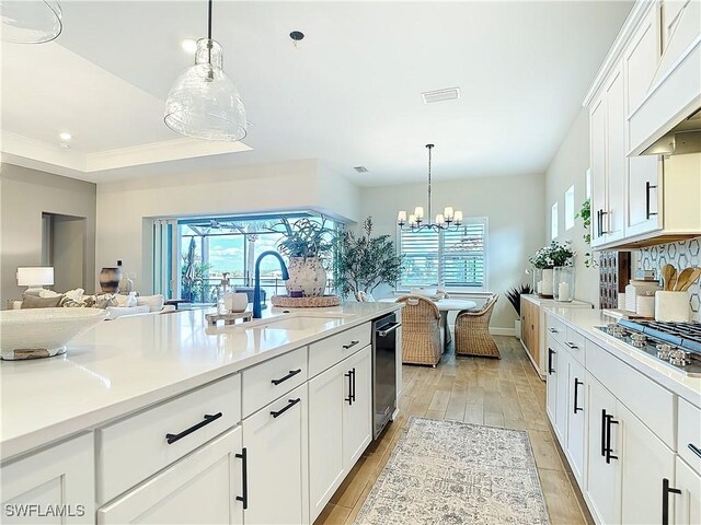 7041 Del Webb Oak Creek Blvd, North Fort Myers, FL 33917 - kitchen featuring custom exhaust hood, a wealth of natural light, stainless steel gas stovetop, light wood-style flooring, and a sink
