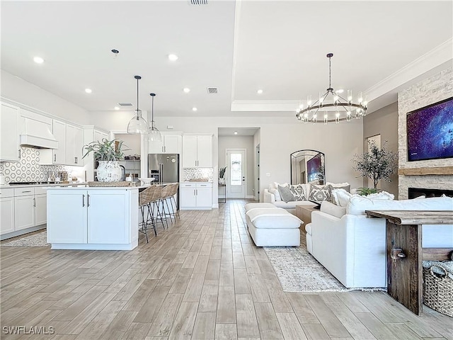 7041 Del Webb Oak Creek Blvd, North Fort Myers, FL 33917 - living room featuring ornamental molding, light wood-type flooring, visible vents, and recessed lighting