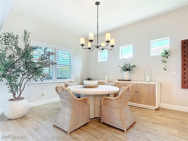7041 Del Webb Oak Creek Blvd, North Fort Myers, FL 33917 - dining space with light wood finished floors, baseboards, and a notable chandelier