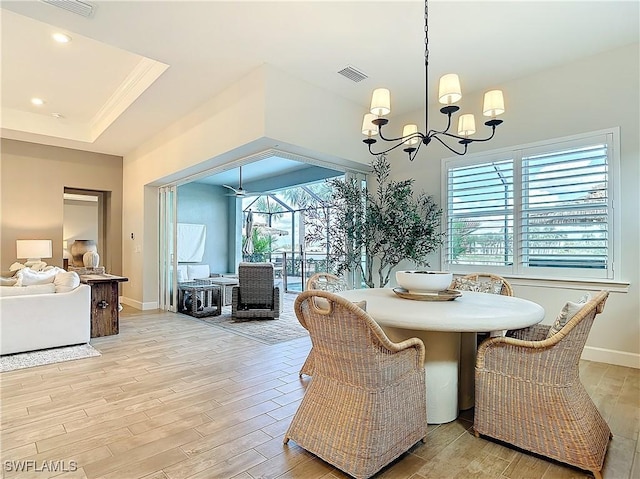 7041 Del Webb Oak Creek Blvd, North Fort Myers, FL 33917 - dining room featuring a raised ceiling, visible vents, light wood-style floors, a sunroom, and baseboards