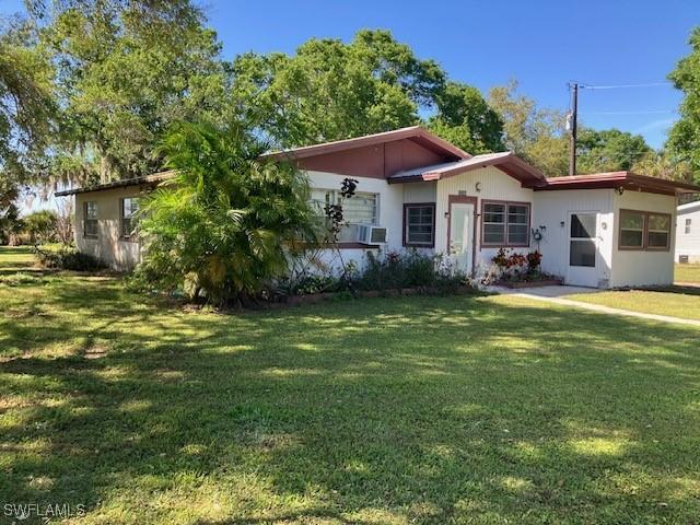 view of front of home with cooling unit and a front yard