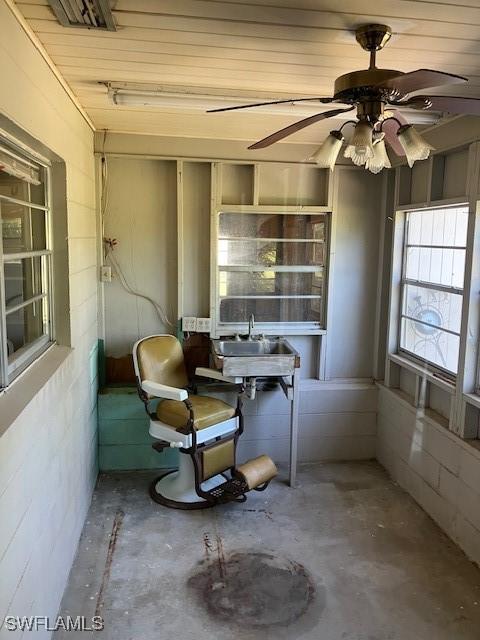 interior space with unfinished concrete flooring and ceiling fan