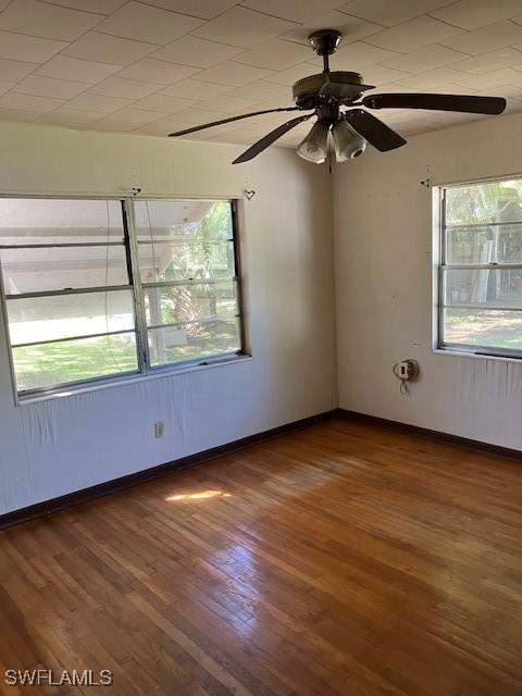 unfurnished room with ceiling fan, baseboards, and wood finished floors