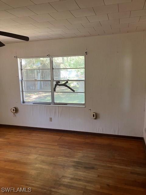 unfurnished room with baseboards and wood finished floors