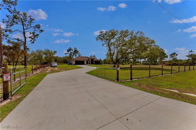 view of front of house featuring a garage, a fenced front yard, concrete driveway, and a front yard