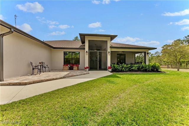 back of house featuring a patio, a lawn, and stucco siding