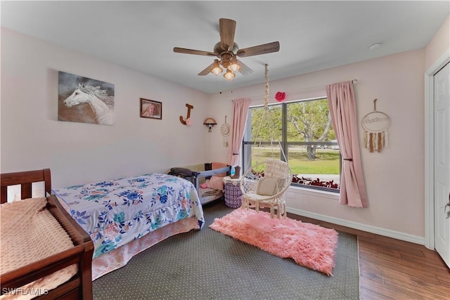 bedroom with a ceiling fan, baseboards, and wood finished floors