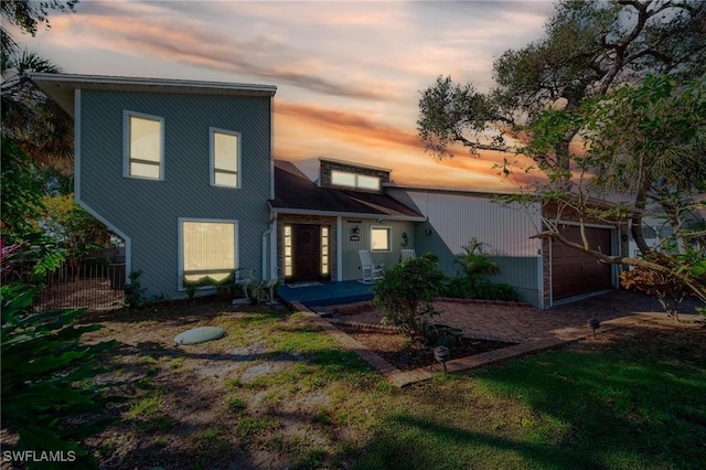 view of front of property featuring an attached garage and fence